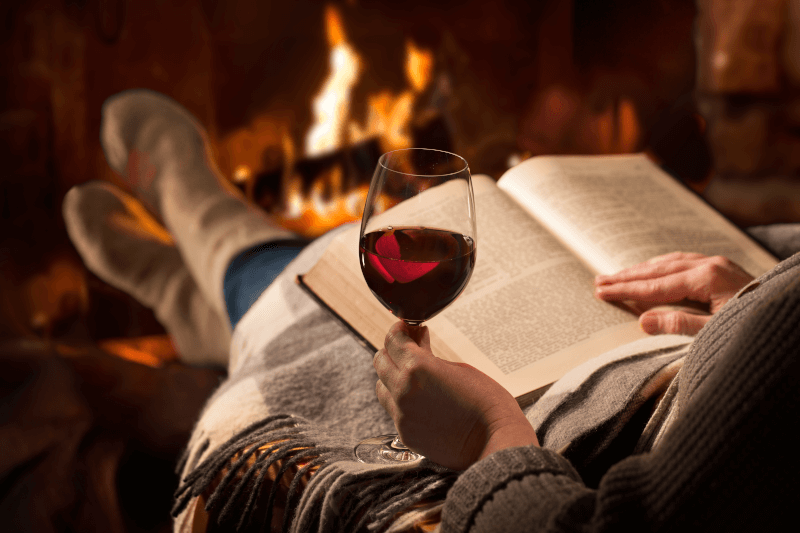 Con libro y vino frente a la chimenea Mit-Buch-und-Wein-vorm-Kamin